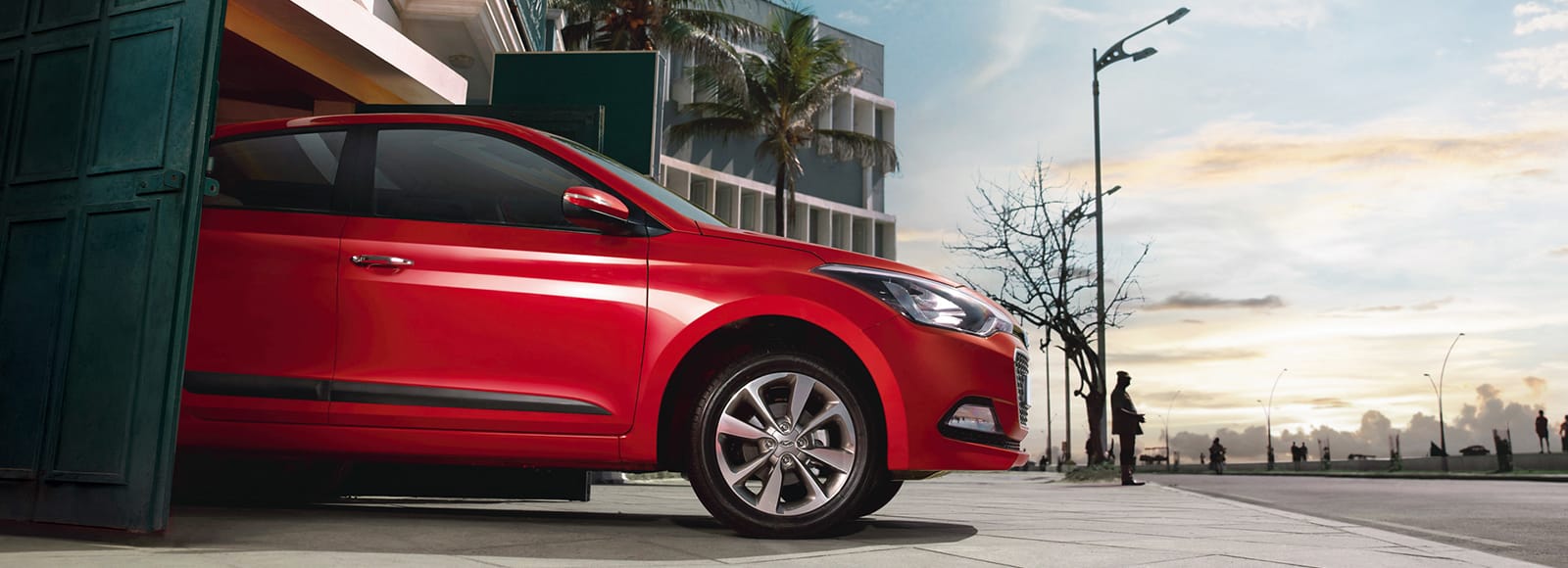 Side view of red Elite i20 driving out from the car garage
