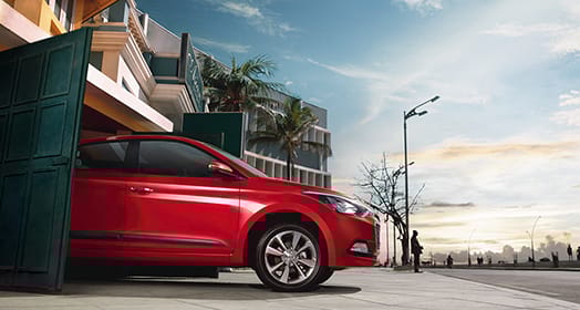 Side view of red Elite i20 driving out from the car garage