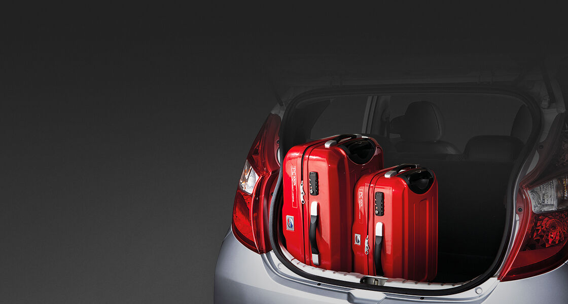 Two red luggage loaded in trunk