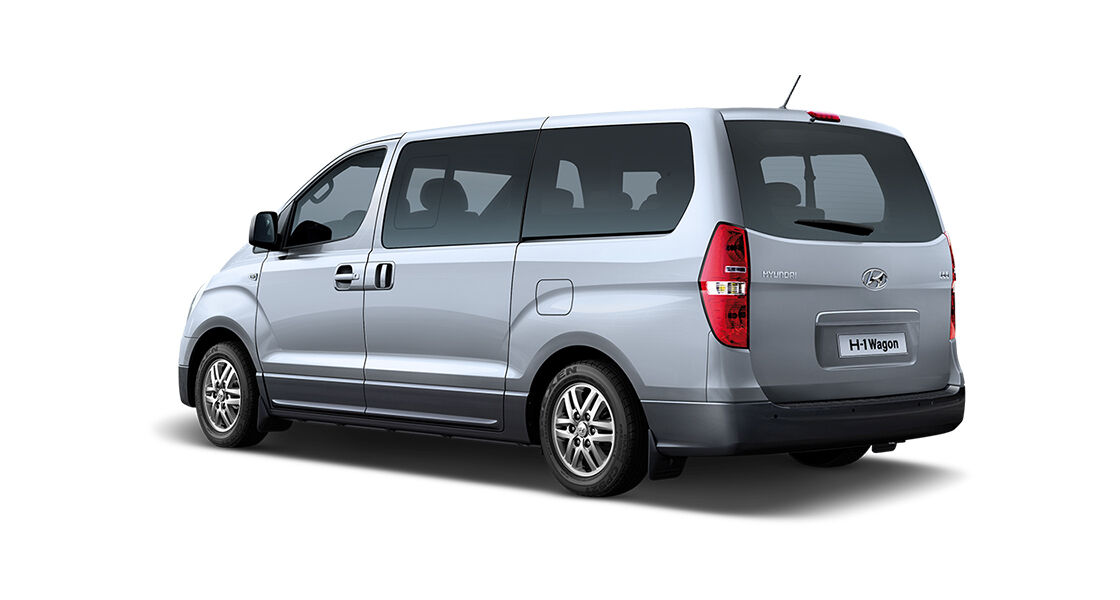 Left rear view of a silver van with black back ground