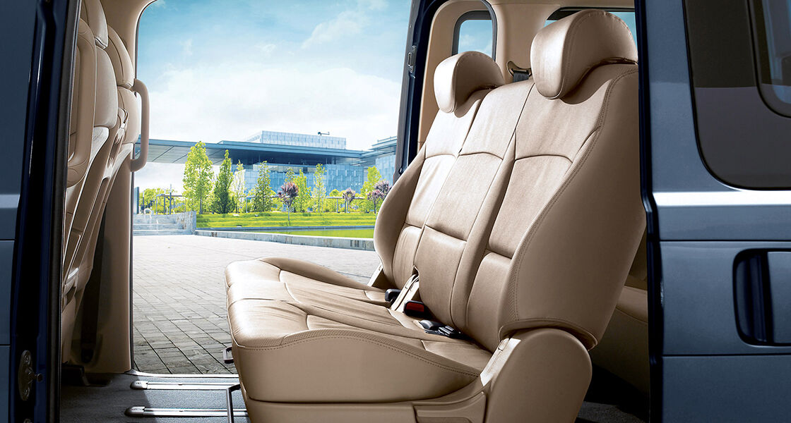 Two beige seats near the center door of H-1