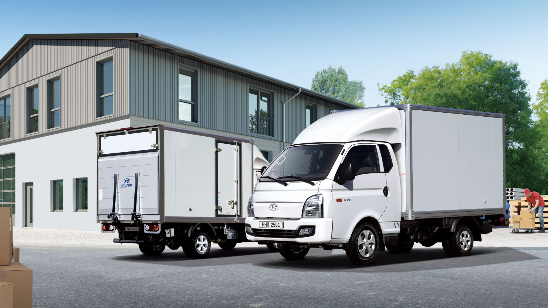 A built-in model vehicle parked in front of a logistics warehouse, with a person organizing goods to be loaded behind the vehicle.