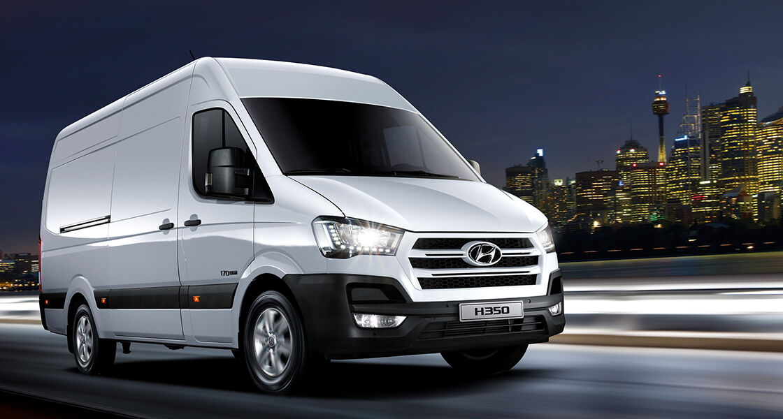 Right side front view of white H350 driving at night