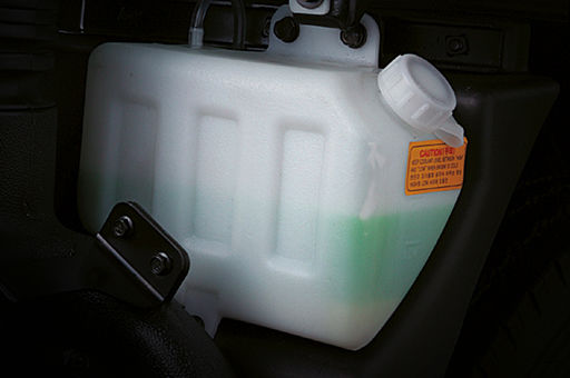 The green fluid is contained in a white plastic bottle