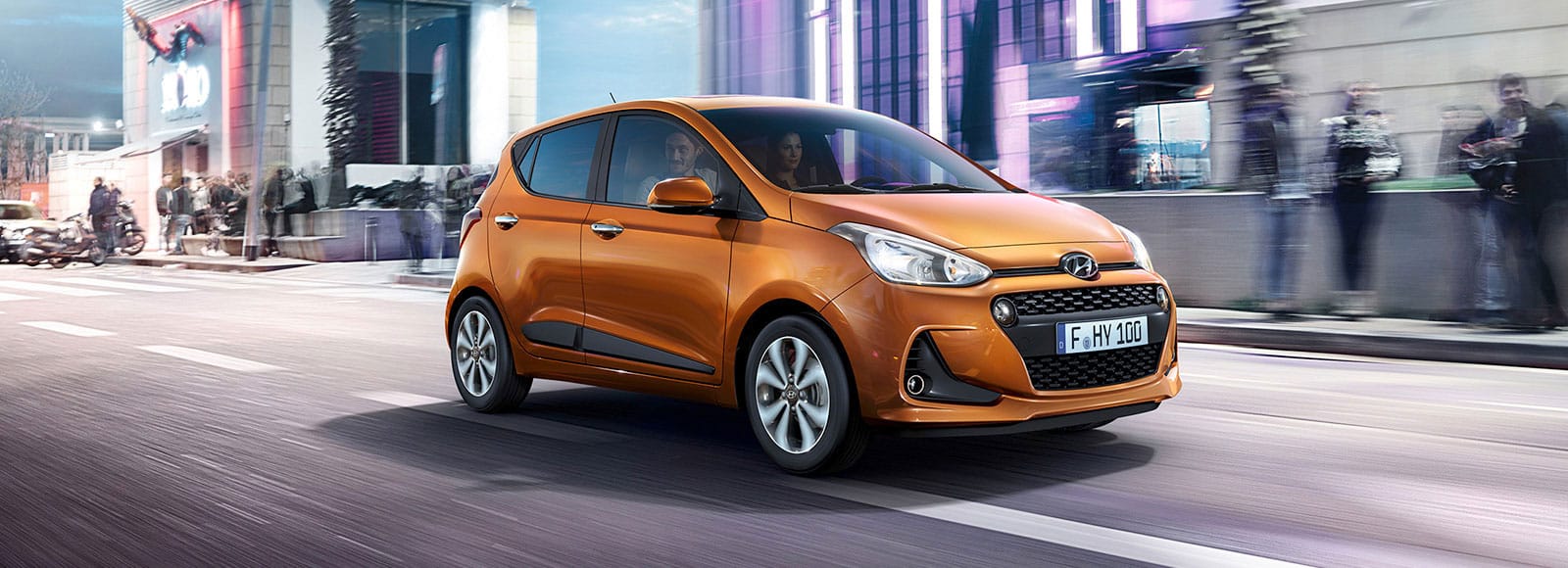 Side front view of orange i10 driving on the road