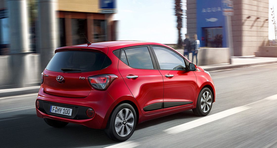 Side rear view of red i10 driving on the road