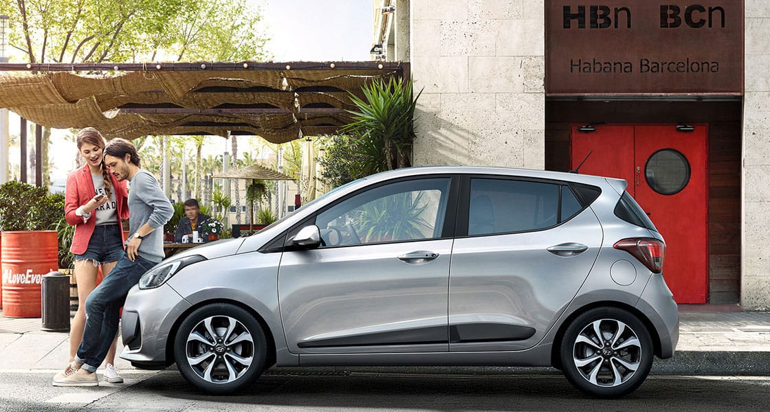 Side view of silver i10 parked on the road in the city