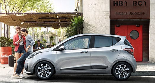 Side view of silver i10 parked on the road in the city