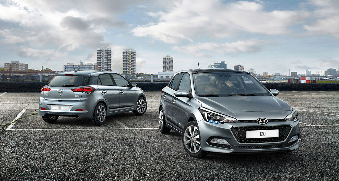 Front side view of dark gray i20 in front and side-rear view of dark gray i20 parked behind with skyline view