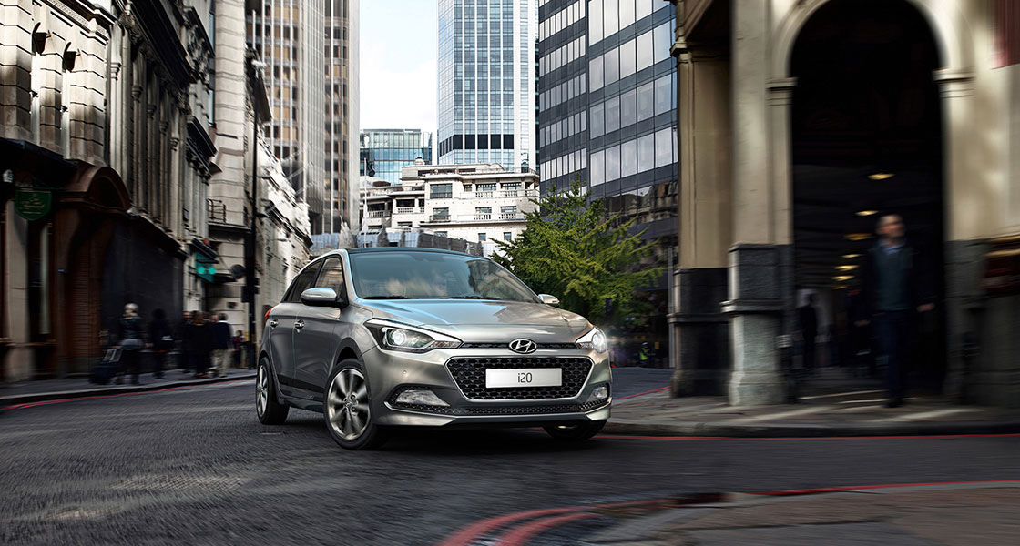 Front view of silver i20 passing by buildings