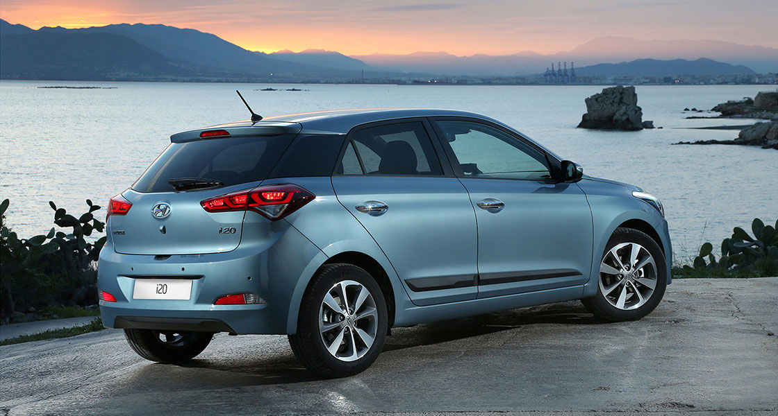 Right side rear view of skyblue i20 parked on the road with the river beside