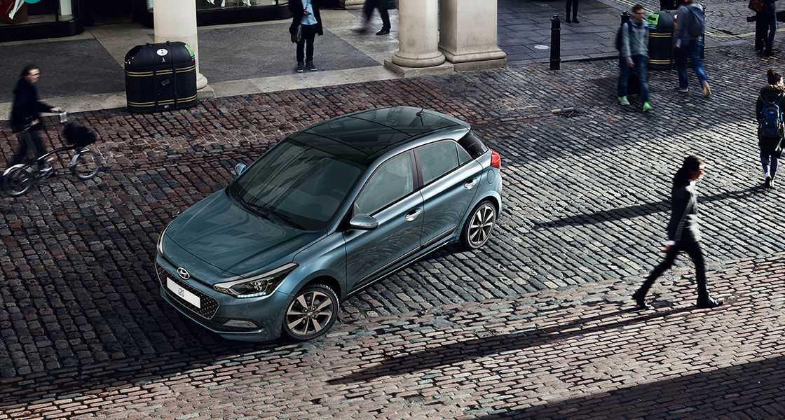 Sky view of turquoise i20 parked on the street and many people passing by