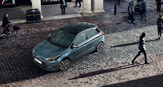 Sky view of turquoise i20 parked on the street and many people passing by