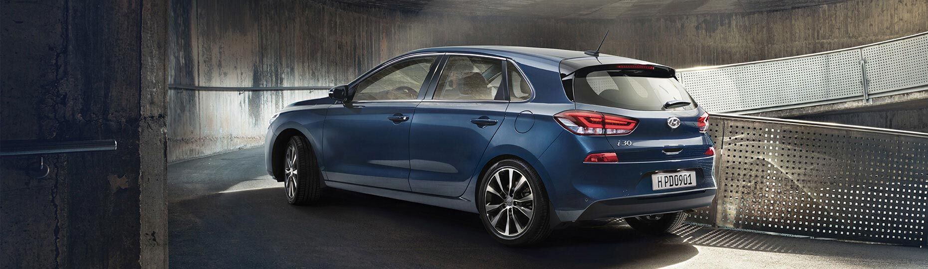 Left side rear view of blue i30 on the uphill road