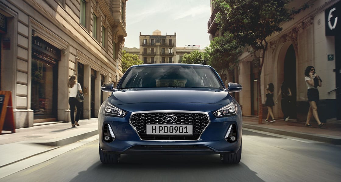 منظر أمامي جانبي لسيارة آي30 الزرقاء تسير على الطريق