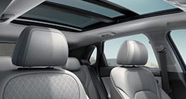 صورة من زاوية منخفضة لمقصورة داخلية بلون بيج وتظهر فتحة السقف مفتوحة في يوم صحو