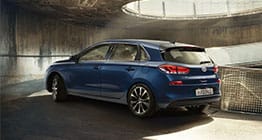 منظر خلفي للجانب الأيسر لسيارة آي30 الزرقاء تسير على الطريق الصاعد