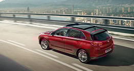 منظر خلفي للجانب الأيسر لسيارة آي30 الحمراء تسير على الطريق