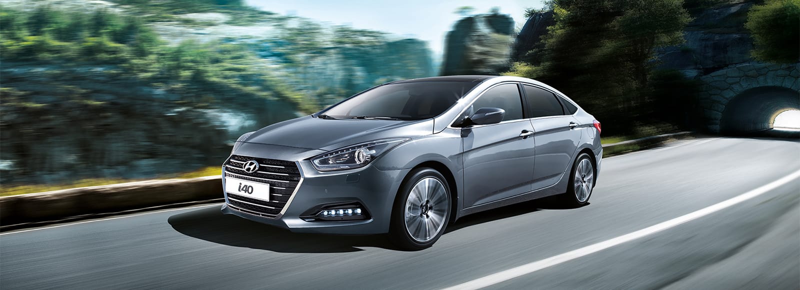 Side front view of gray i40 Sedan driving on the road