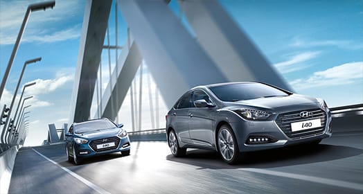 One dark gray and one blue i40 sedan driving in line on the bridge