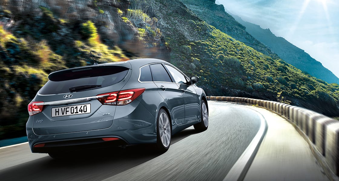 Right side rear view of dark gray i40 driving on the mountainous road