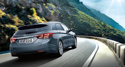 Right side rear view of dark gray i40 driving on the mountainous road