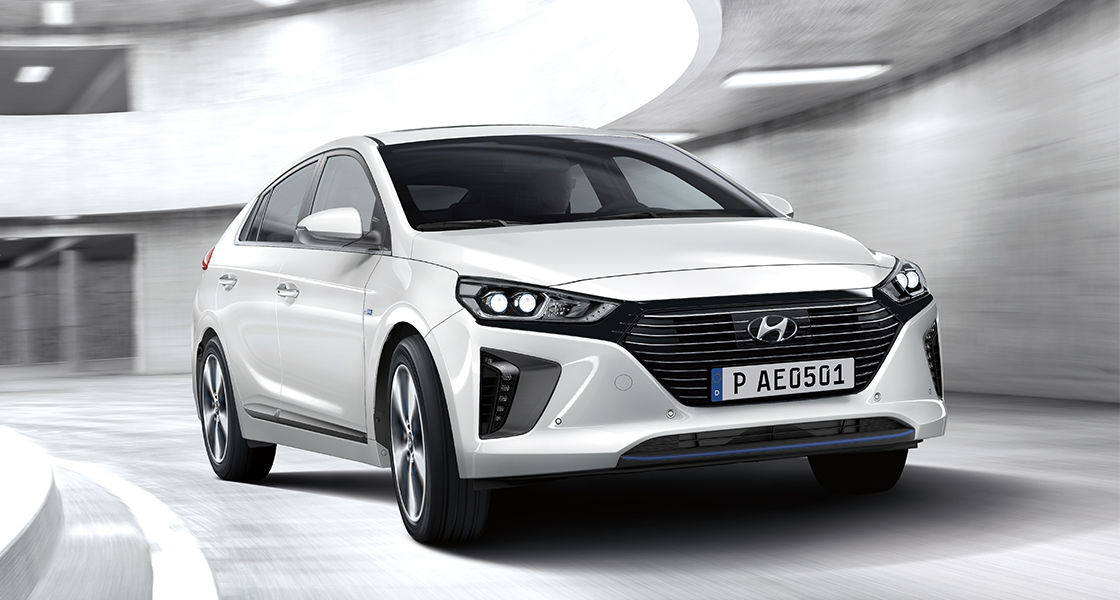A driver approaching to the side of white Ioniq plug-in hybrid