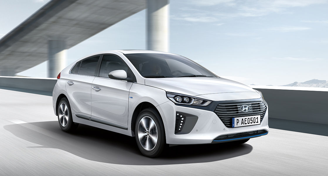 Side front view of white Ioniq plug-in hybrid driving on the highway
