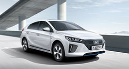 Side front view of white Ioniq plug-in hybrid driving on the highway