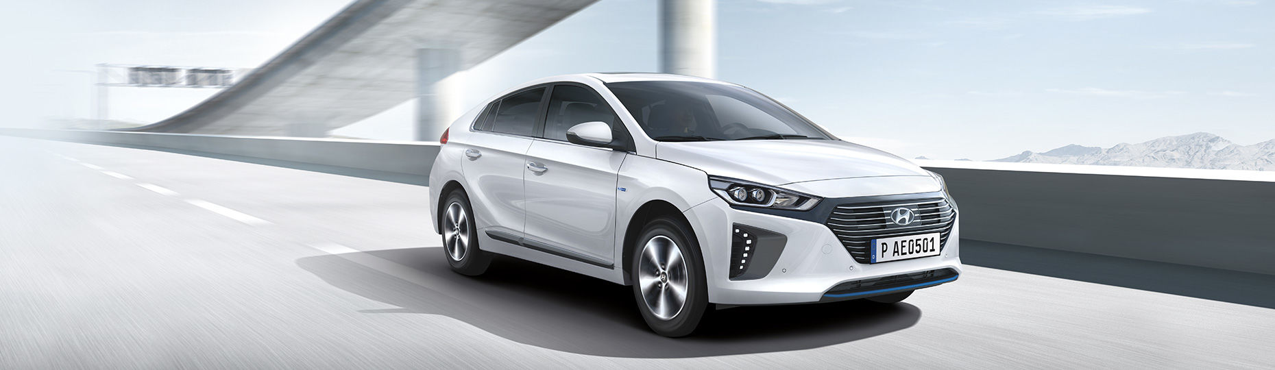 White Ioniq plug-in Hybrid is driving on the road under the bridge