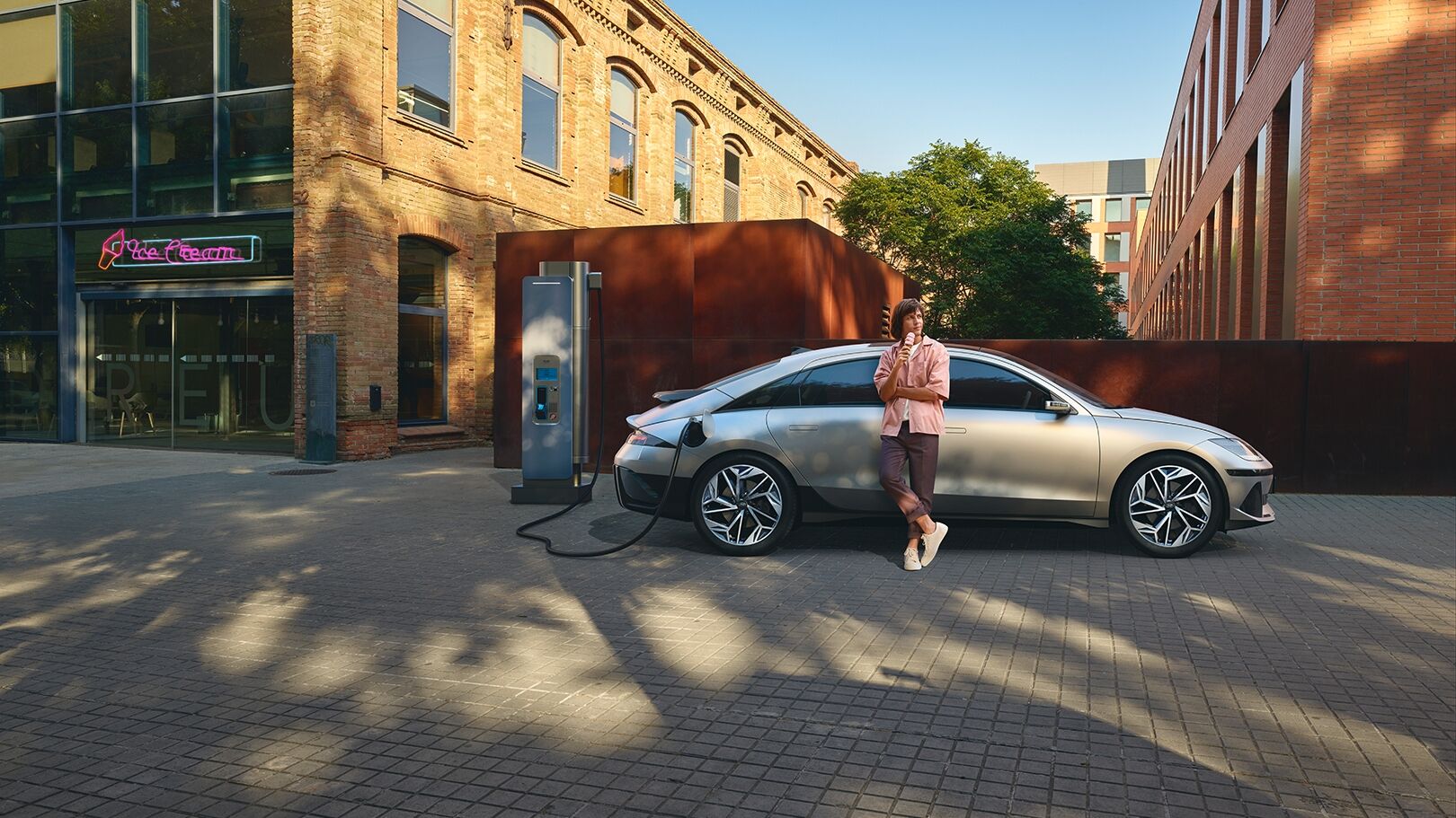 man eating ice cream leaning on right side of IONIQ 6