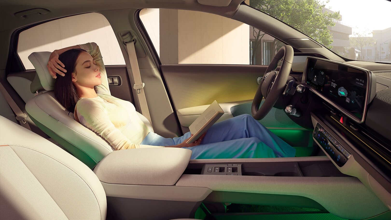 woman reading a book sitting in the front of IONIQ 6