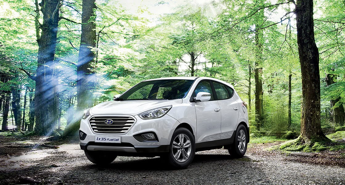 Side front view of white ix35 Fuel Cell parked in the forest