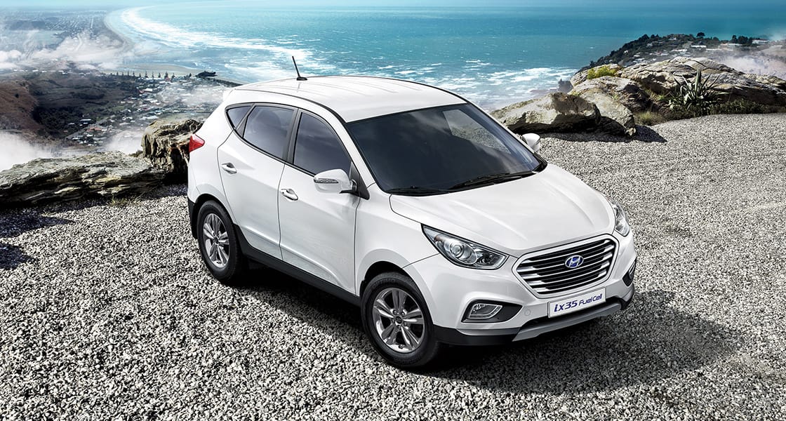 Side front view of white ix35 Fuel Cell parked on the seashore