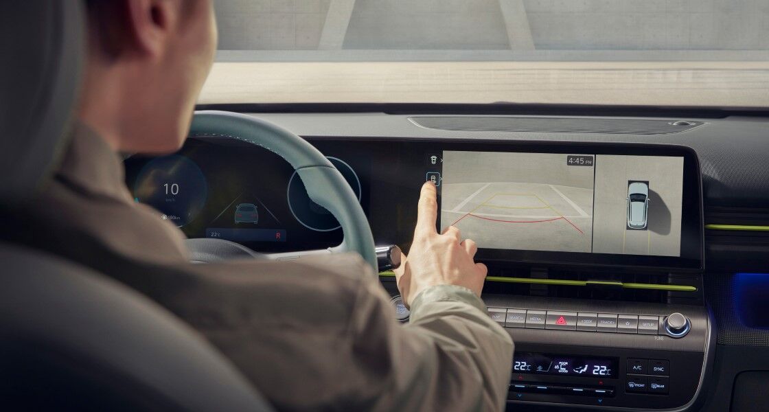 Rear view of the person sitting in the The all-new KONA driver's seat operating the touch screen in front of the driver's seat.