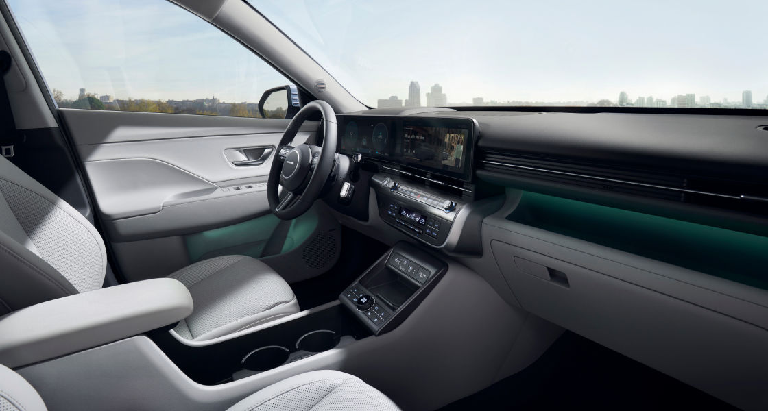 منظر لمقعد السائق من مقعد الراكب في السيارة كونا الجديدة كليًا. باب السائق مفتوح ويتم عرض الرسائل المتعلقة بالسلامة على الشاشة.