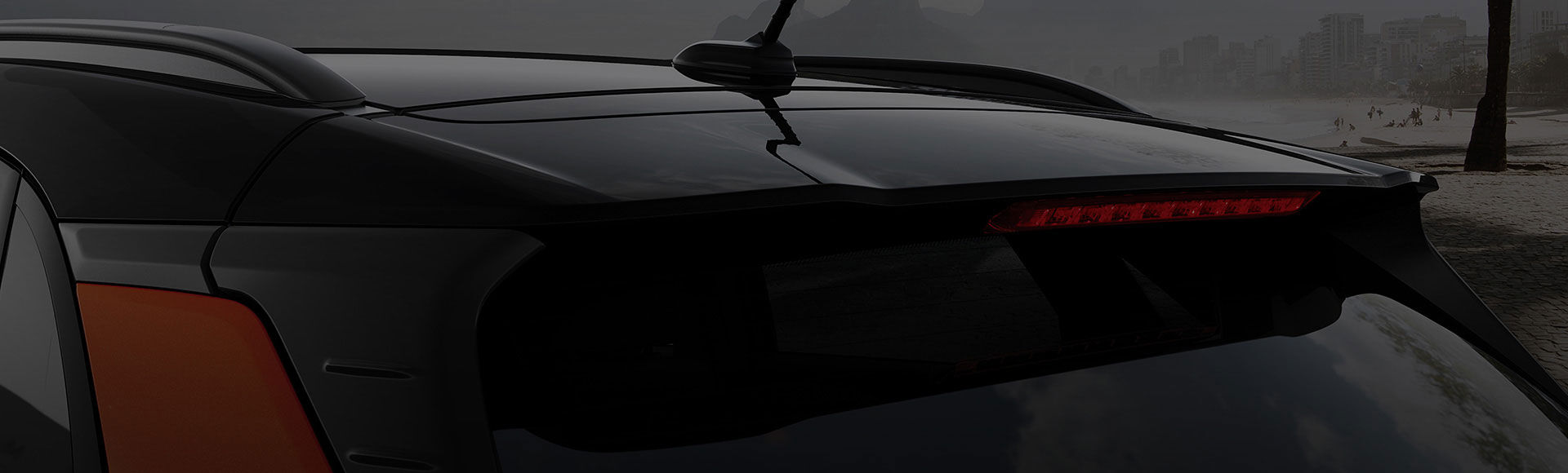 Closer view of left side rear view of red kona on the road