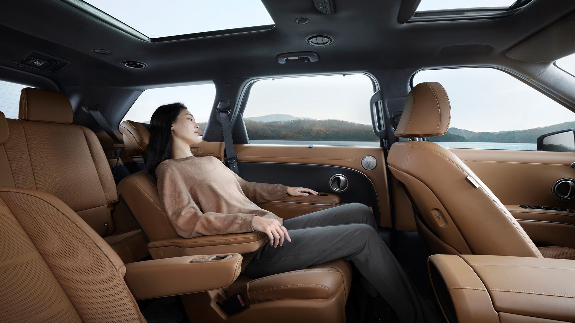 A woman relaxing in the second row seat inside the all-new PALISADE