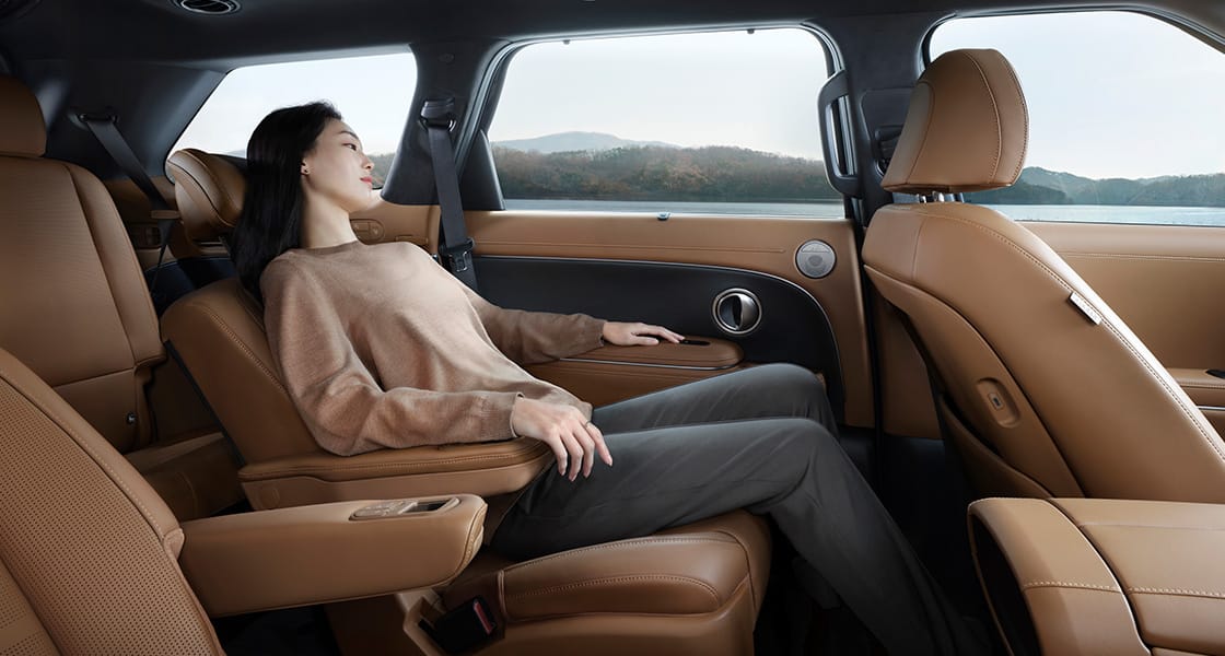 A woman relaxing in the second row seat inside the all-new PALISADE