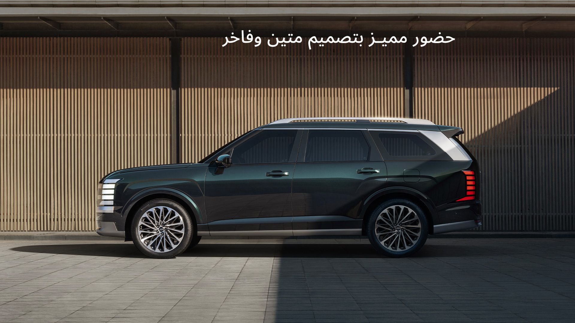 The all-new PALISADE side view, in front of a wall