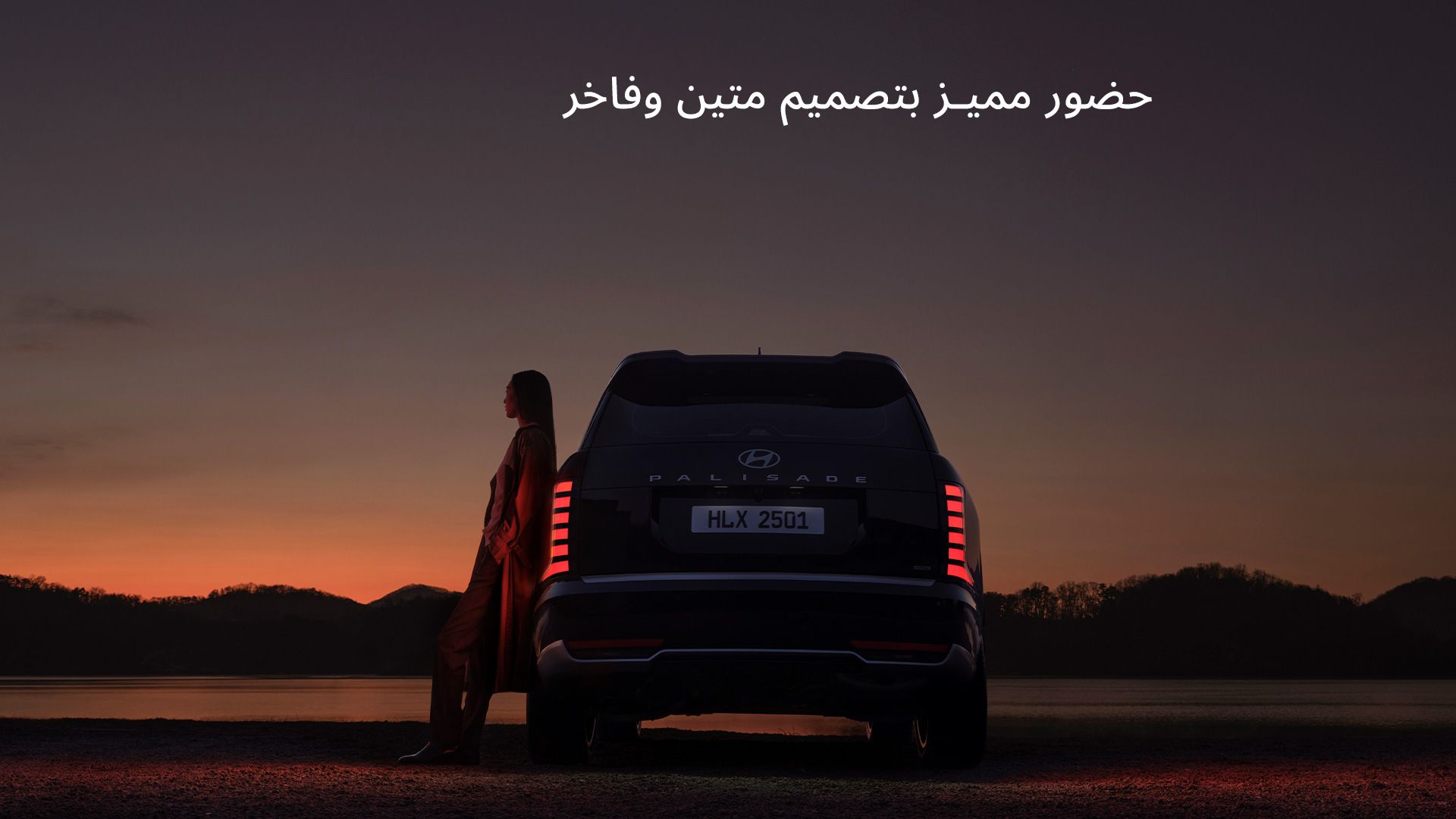 A woman leaning on the side of the all-new PALISADE, gazing at the sunset