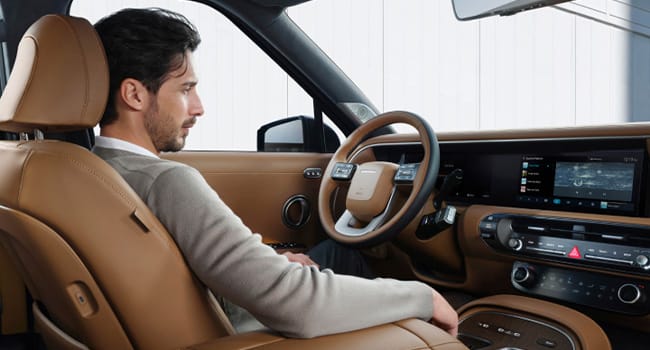 A man relaxing comfortably in the all-new PALISADE during STAY mode.