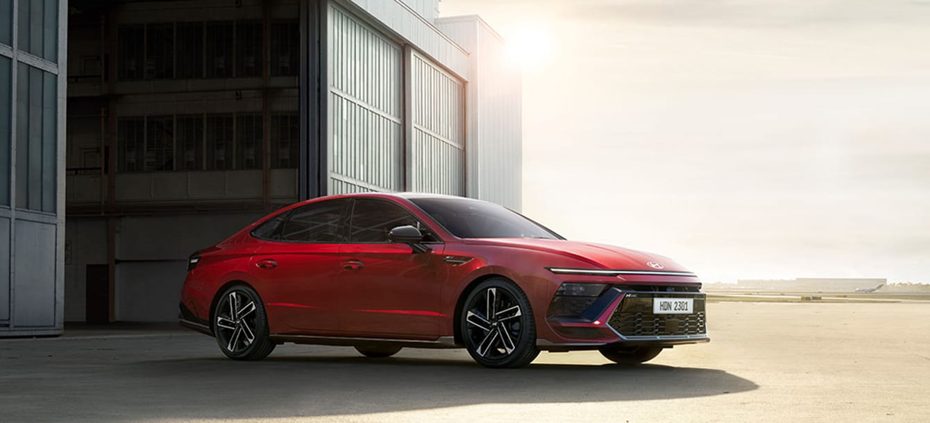 Image of the red The new SONATA standing in front of the garage