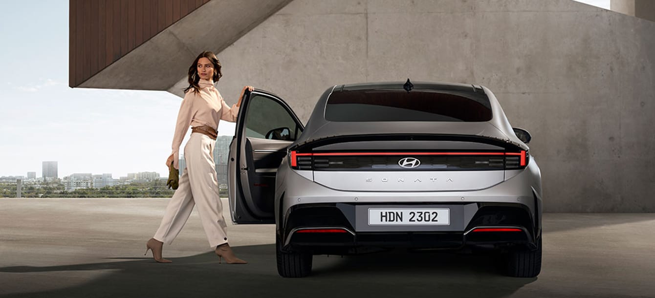 Image of a woman opening the driver's door of the gray The new SONATA