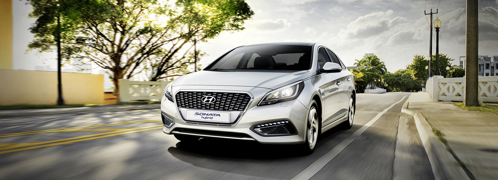 Front view of silver Sonata Hybrid driving on the road
