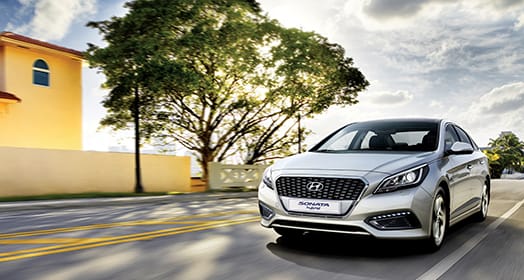Left side front view of silver Sonata hybrid driving on the roadLeft side front view of silver Sonata hybrid driving on the road