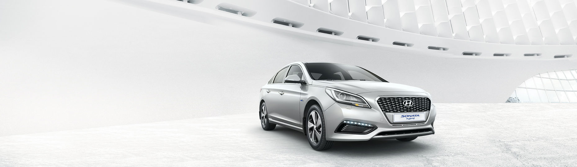 Silver color Sonata Hybrid is placed inside of a building with unique design