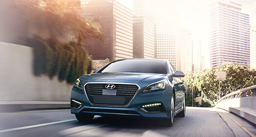 Front view of navy Sonata Plug-in Hybrid driving on the street