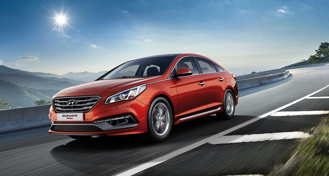 Side front view of red Sonata Turbo on a sunny day