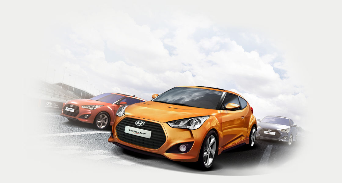 Side front view of three Veloster Turbo Turbo cars driving on the road